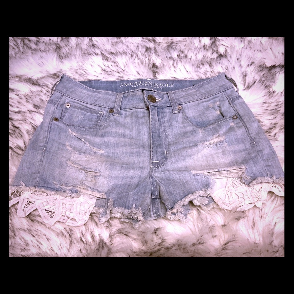 Blue Jean shorts that have white lace pockets